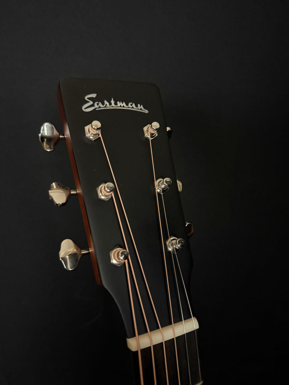 Eastman E1OM-DLX acoustic guitar headstock with eastman logo